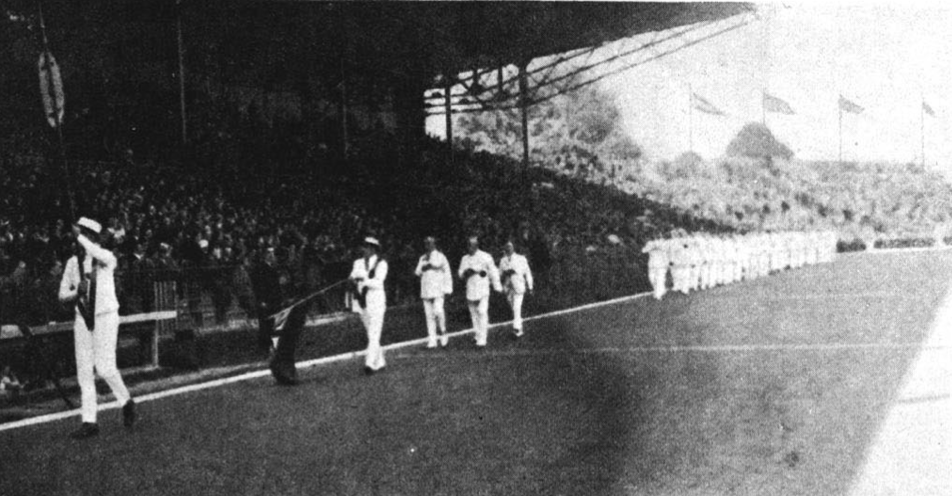 Une photo en noir et blanc d'athlètes marchant dans le stade. 