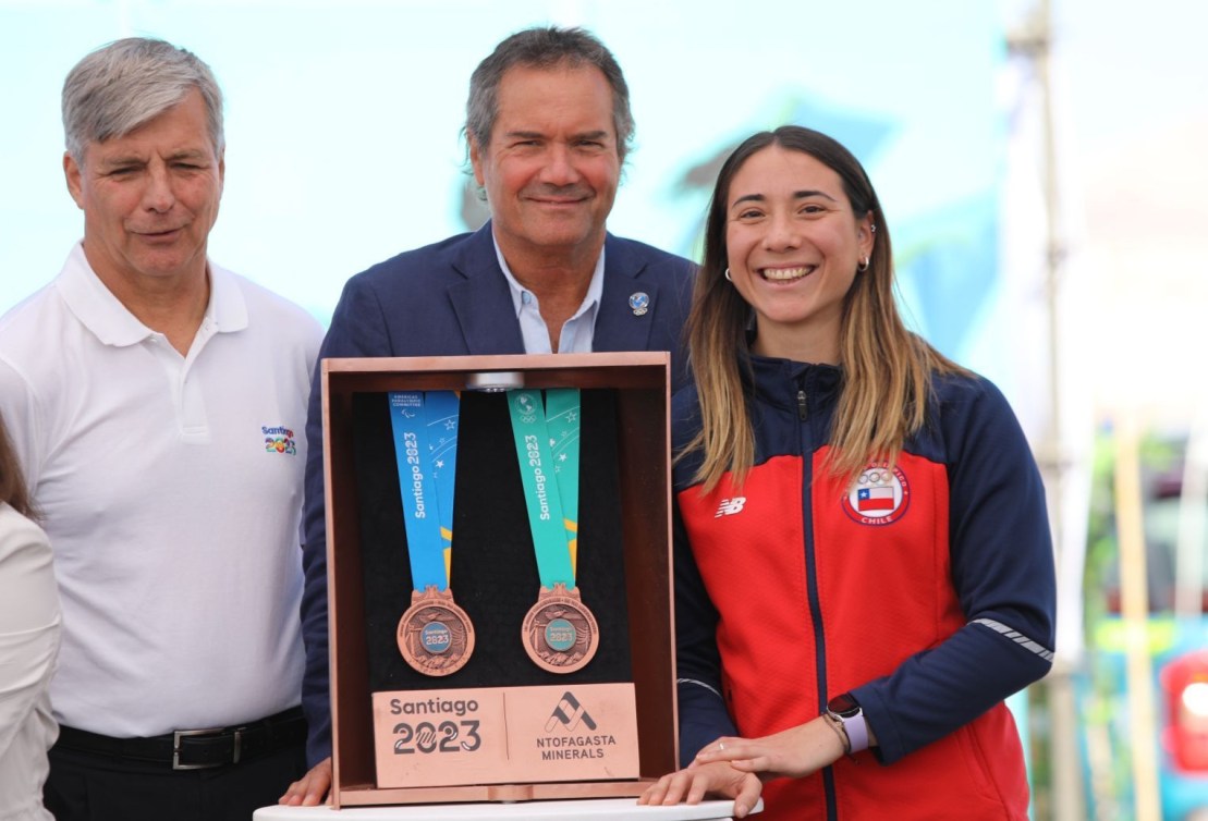 Trois personnes présentent les médailles des Jeux panaméricains et des Jeux parapanaméricains.