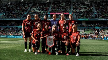L'équipe féminine canadienne de soccer prend la pose pour une séance photo sur le terrain.