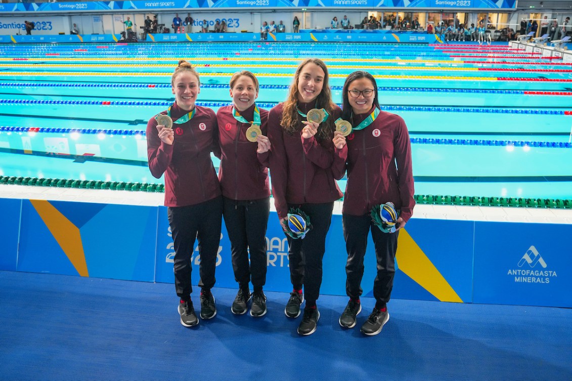Danielle Hanus, Rachel Nicol, Mary-Sophie Harvey et Maggie Mac Neil du Canada posent devant la piscine avec leurs médailles d'or