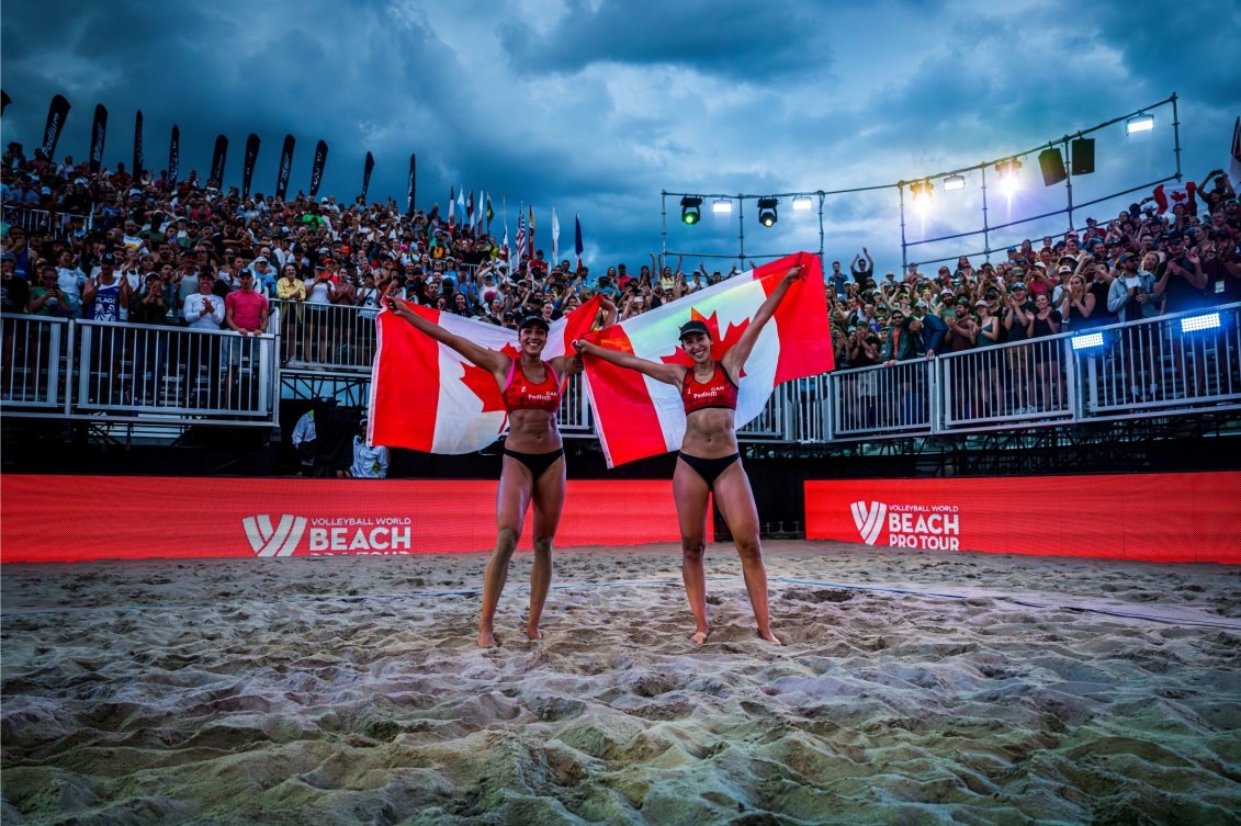 Melissa Humana-Paredes et Brandie Wilkerson célèbrent leur victoire en tenant des drapeaux canadiens derrière elles. 