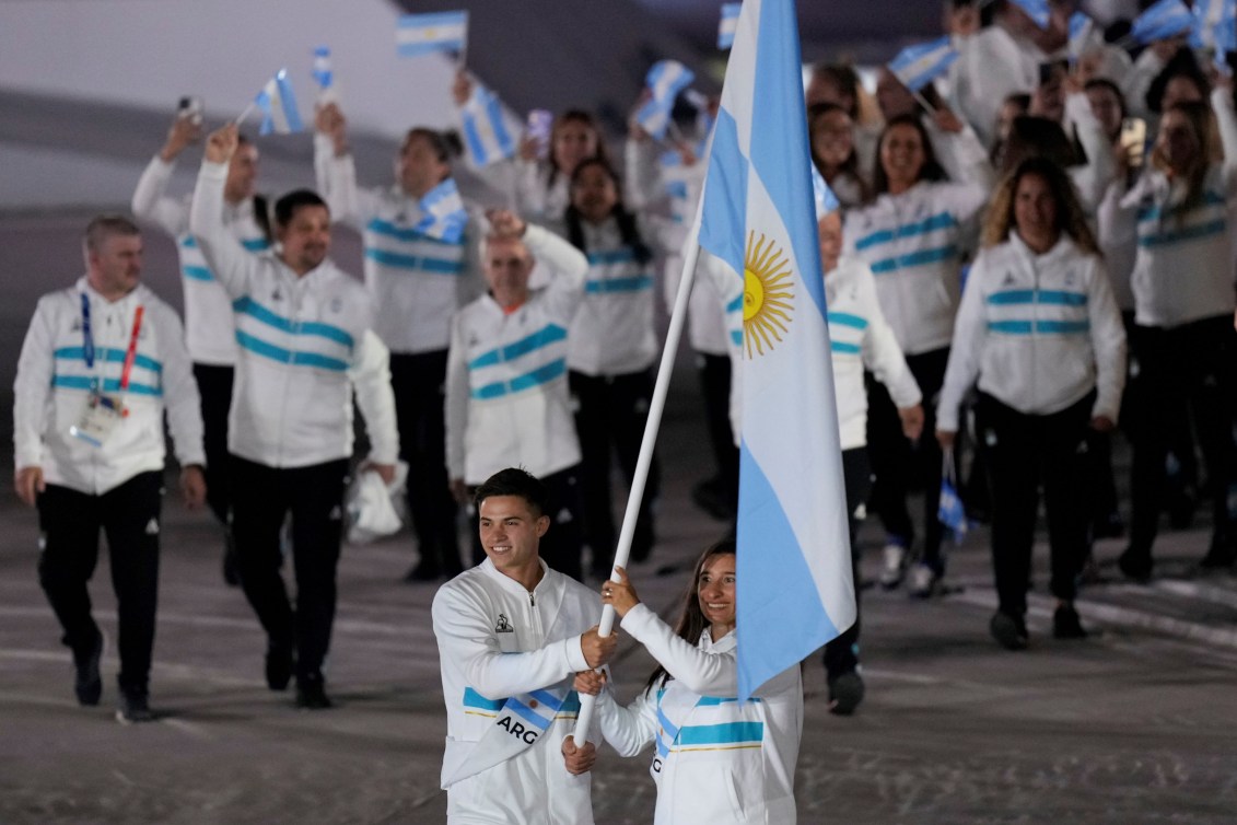 Sabrina Ameghino et Marcos Moneta de l'Argentine portent le drapeau de leur pays. Leurs coéquipiers sont derrière.
