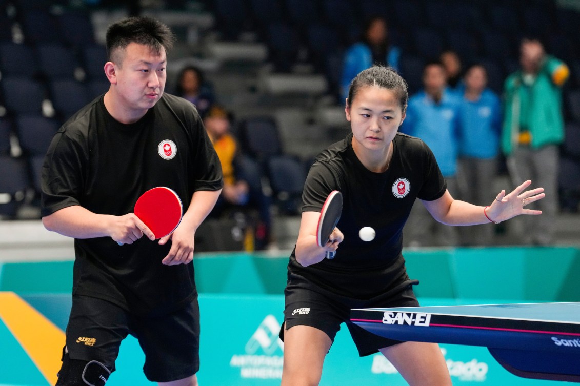 Eugene Wang, à gauche, et Mo Zhang du Canada lors d'un match de tennis de table. 
