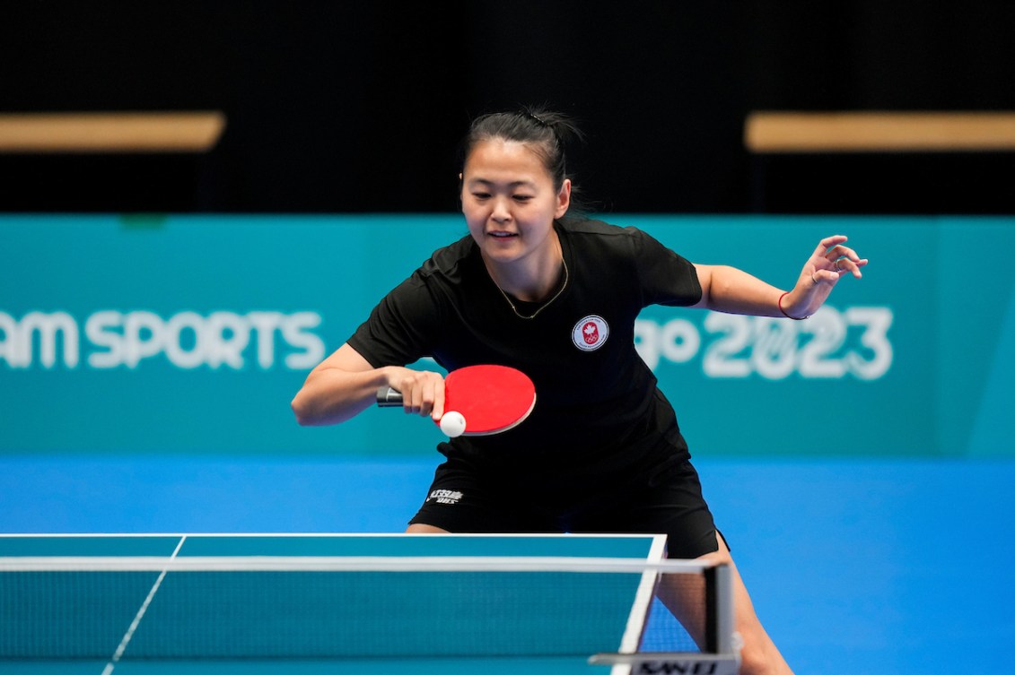 Mo Zhang frappe la balle pendant un match de tennis de table.