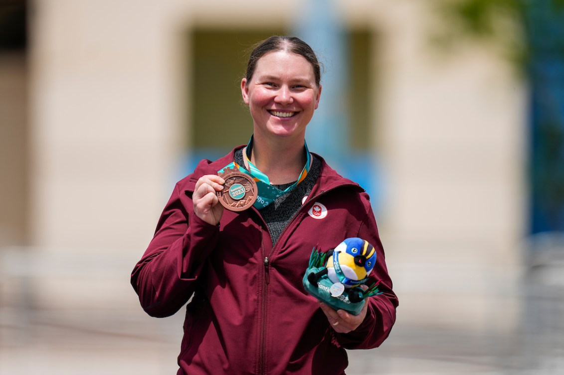 Shannon Westlake tient dans la main droite une médaille de bronze et dans la main gauche une peluche.