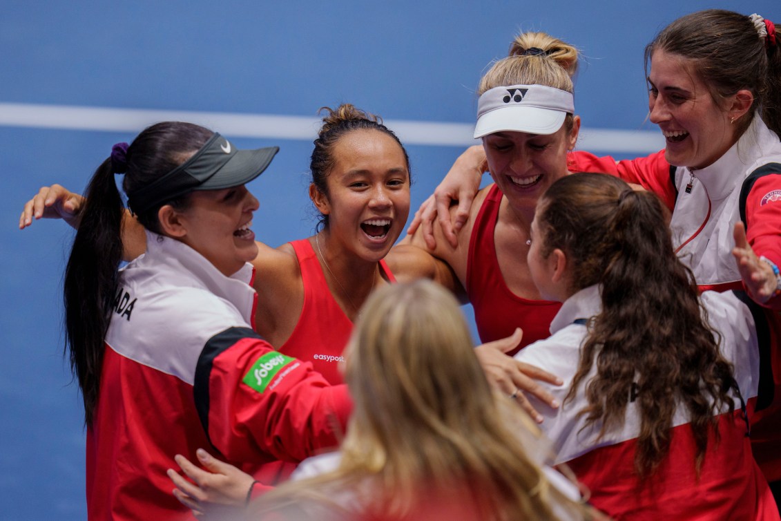 Les joueuses de tennis canadiennes célèbrent sur le terrain. 