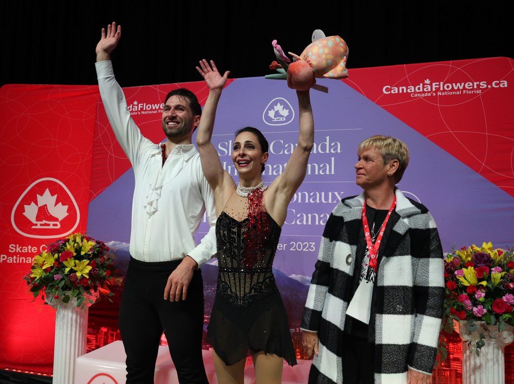 Deanna Stellato-Dudek et Maxime Deschamps du Canada, ainsi que l'entraîneure Josée Picard lèvent les bras dans les airs.