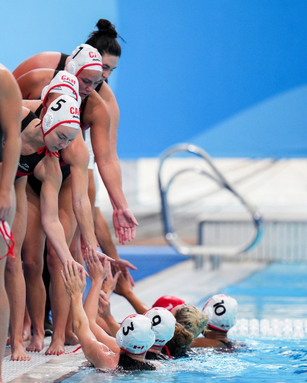 Les joueuses de water-polo d'Équipe Canada se donnent la main. 