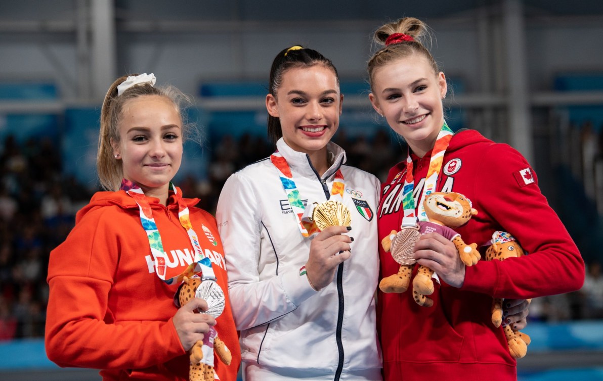 Trois athlètes féminines posent avec leur médaille. 