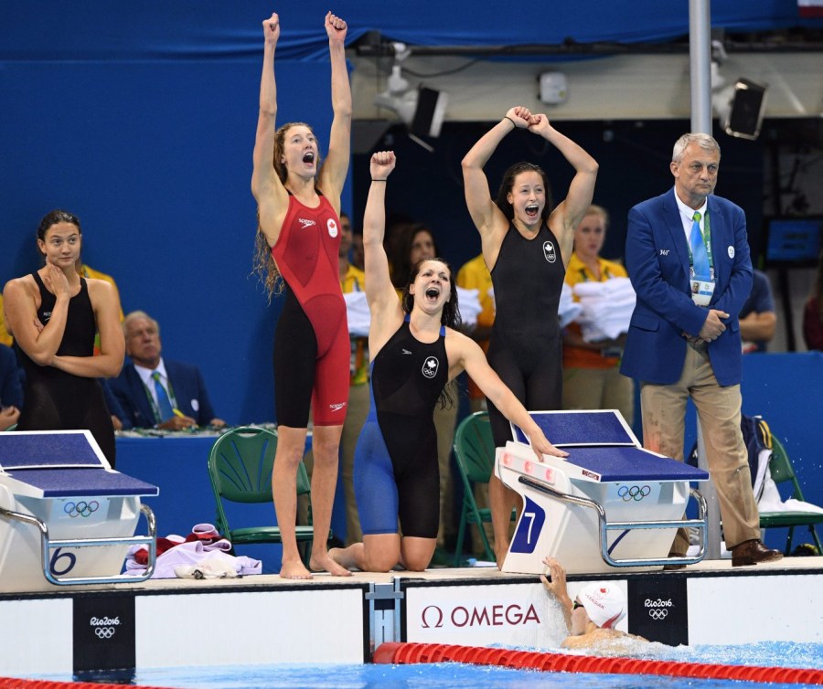 Des nageuses célèbrent sur le bord de la piscine. 