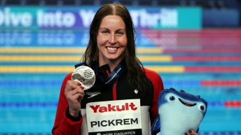 Une nageuse pose avec sa médaille d'argent.