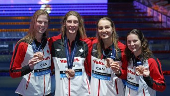 Quatre nageuses posent avec leur médaille.