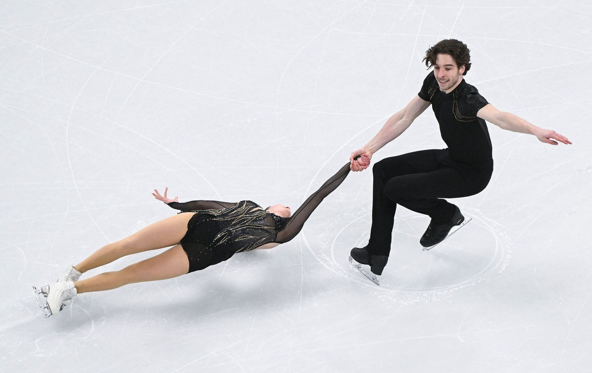 Une patineuse effectue une spirale soutenue par son partenaire.