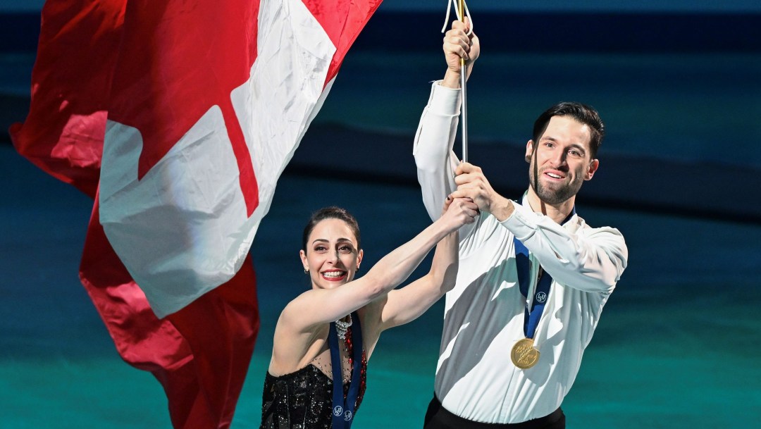 Deanna Stellato-Dudek et Maxime Deschamps du Canada célèbrent avec un drapeau canadien.