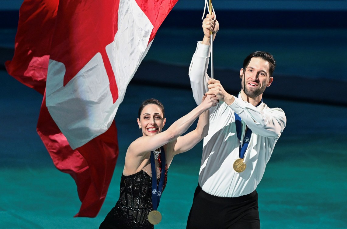 Deanna Stellato-Dudek et Maxime Deschamps du Canada célèbrent avec un drapeau canadien.