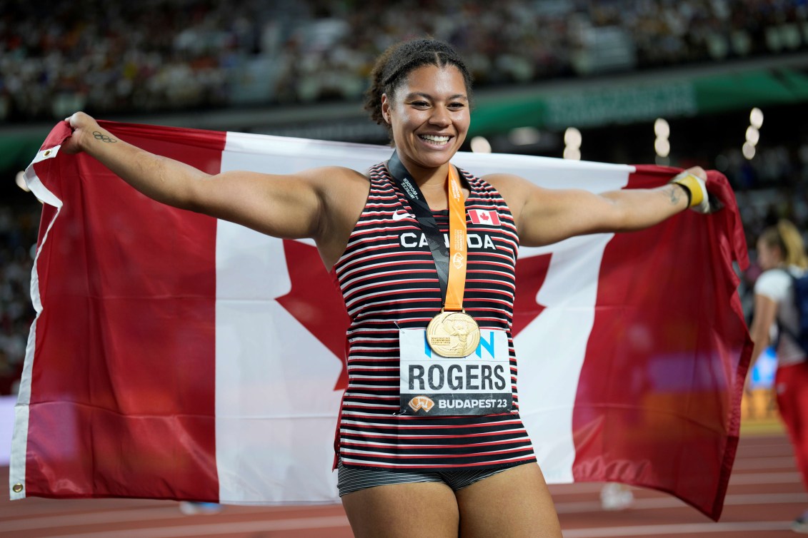 Camryn Rogers avec sa médaille d'or et le drapeau canadien.