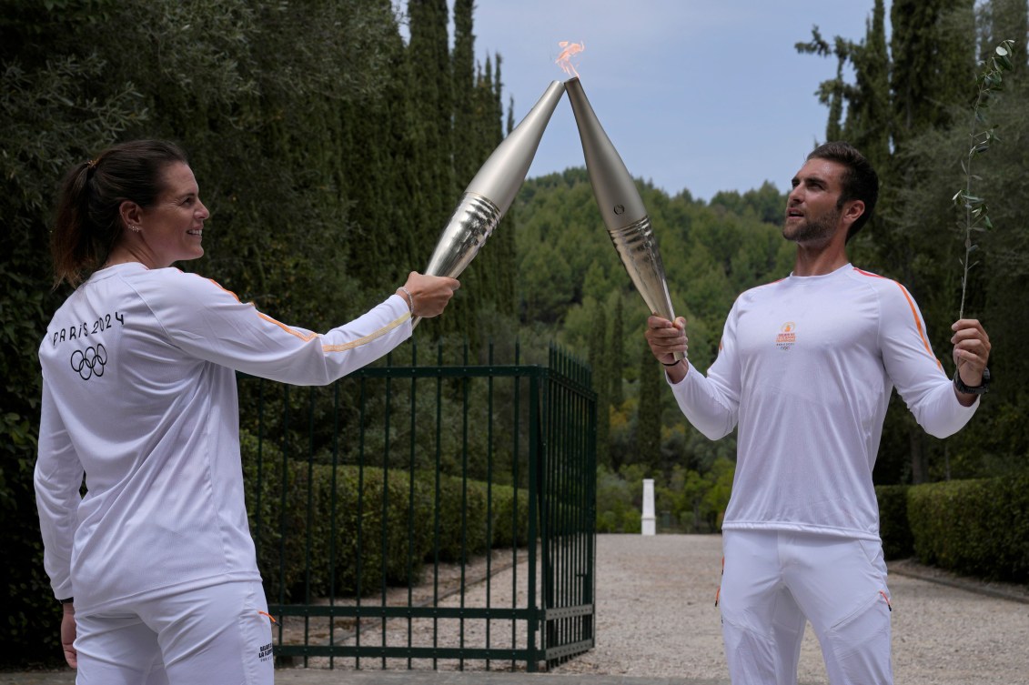 Stefanos Douskos et Laure Manaudou avec les flambeaux allumés. 