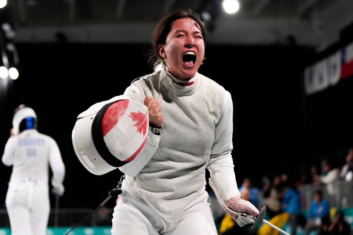 Jessica Guo crie avec son masque dans une main et son fleuret dans l'autre. 