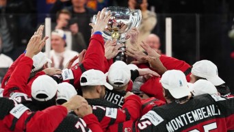 Les joueurs de hockey canadiens soulèvent un trophée.