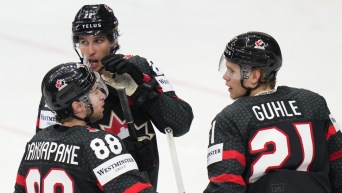 Trois joueurs d'Équipe Canada parlent sur la glace.