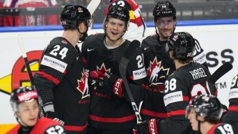 Les joueurs de hockey canadiens dans des chandails noirs célèbrent .