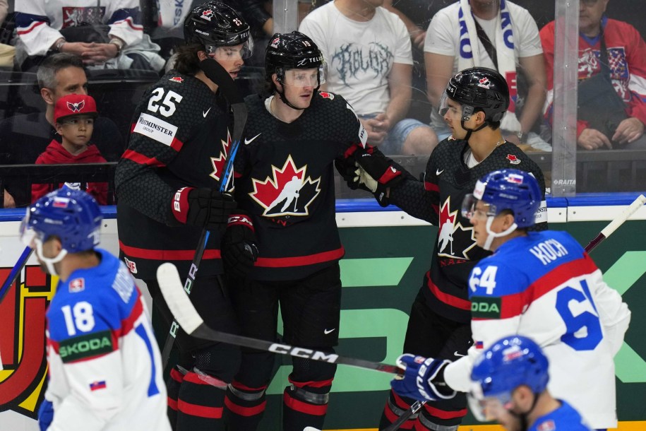 Trois joueurs d'Équipe Canada célèbrent sur la glace.