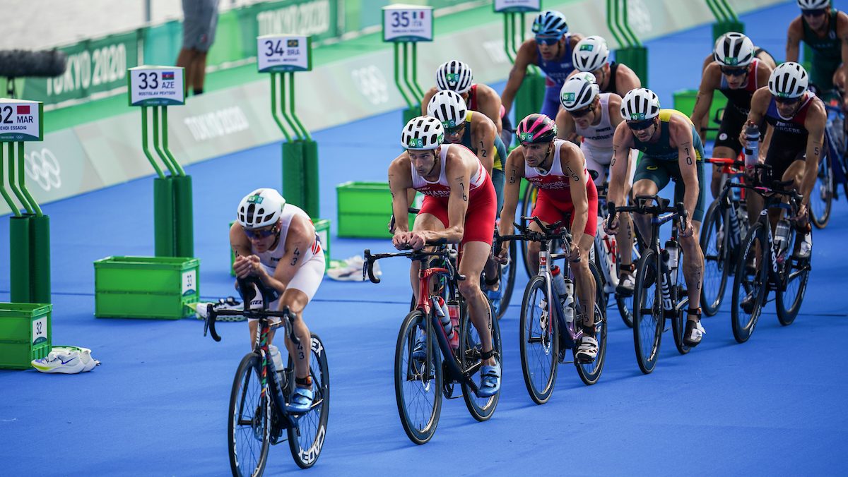 Des athlètes masculins sur leur vélo dans la zone de transition. 