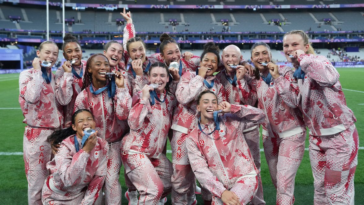 Les joueuses de rugby d'Équipe Canada posent avec leur médaille.