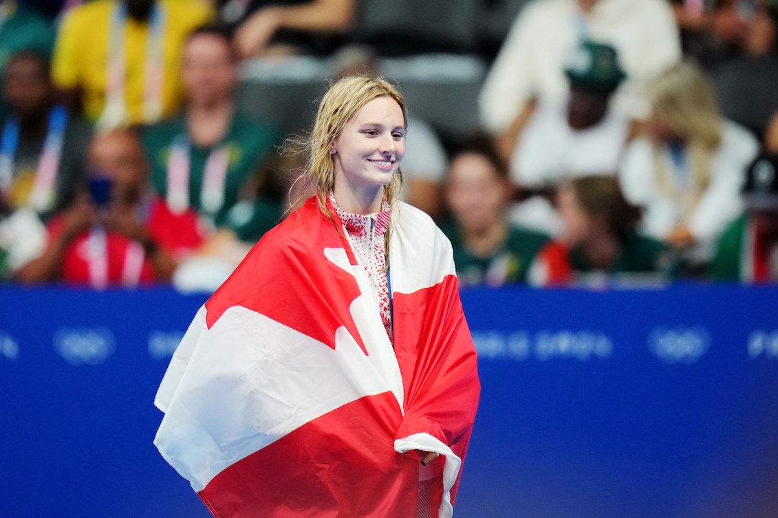 Summer McIntosh drapée dans un drapeau canadien.