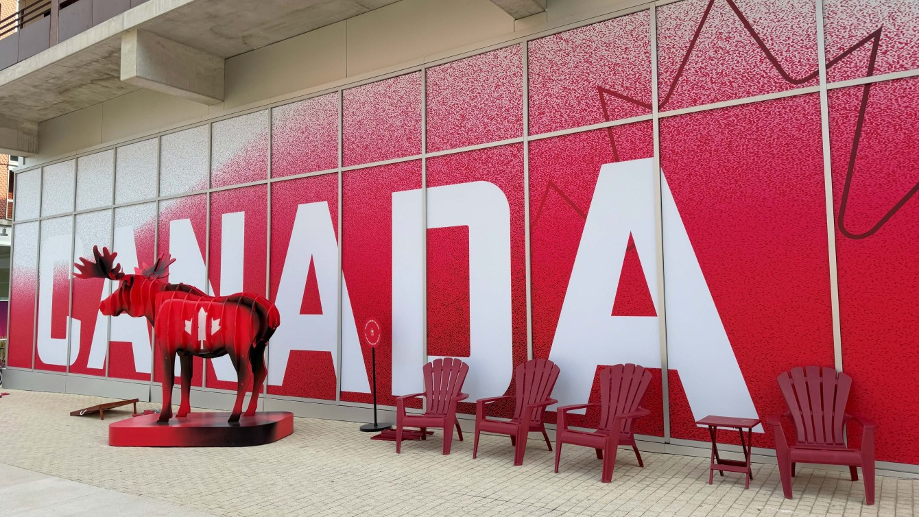 Un orignal rouge devant une affiche Canada.