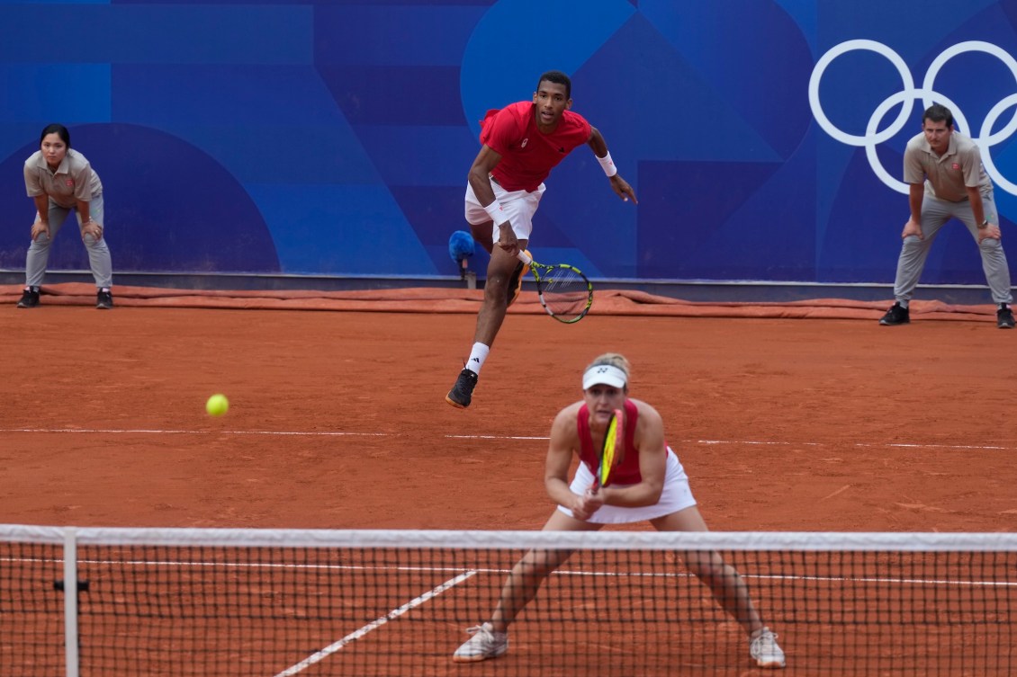 Félix Auger-Aliassime du Canada sert pendant que Gabriela Dabrowski observe.