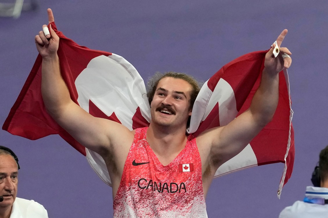 Ethan Katzberg avec un drapeau canadien.