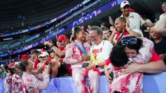 Des joueuses de rugby célèbrent avec des membres de leurs familles dans les gradins.