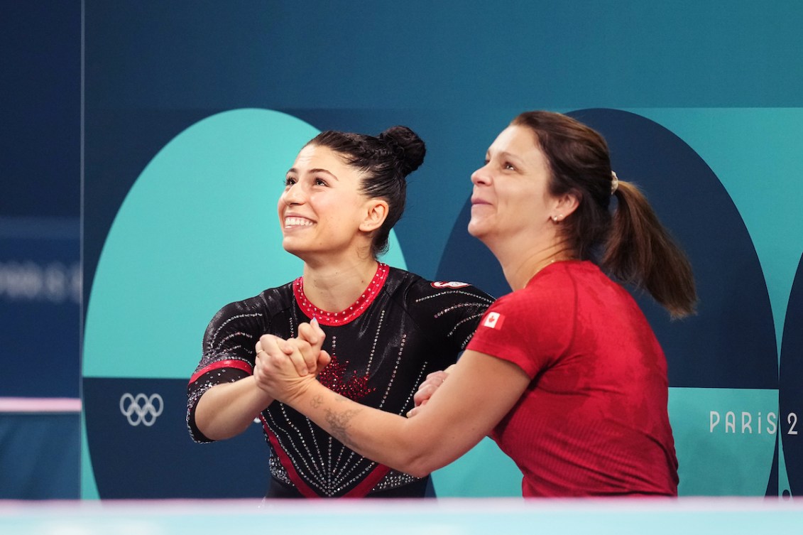 Sophiane Methot célèbre sa médaille de bronze en gymnastique trampoline avec son entraîneur.