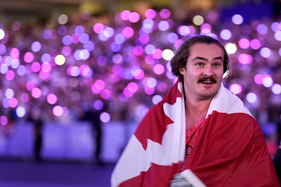 Ethan Katzberg avec un drapeau canadien sur les épaules.