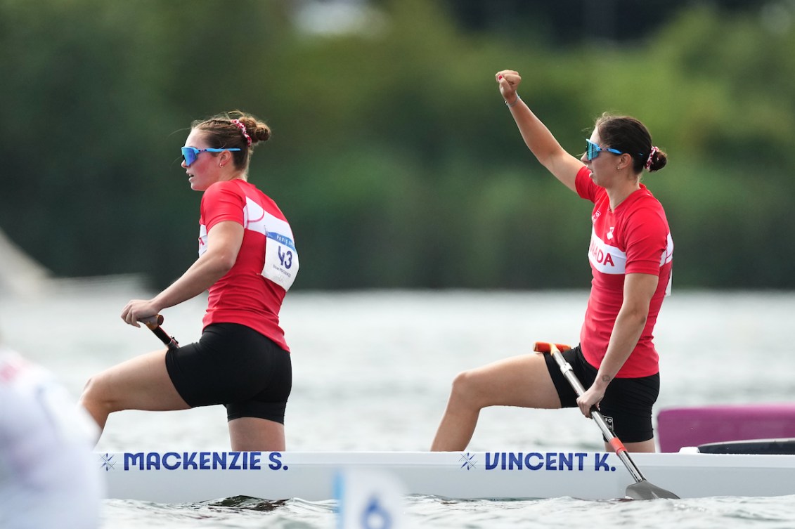 Sloan Mackenzie et Katie Vincent sur leur canoë, Vincent avec le poing droit levé dans les airs.