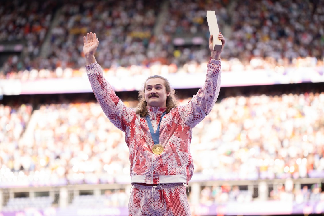 Ethan Katzberg pose sur le podium avec sa médaille d'or. 