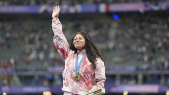 Camryn Rogers célèbre sa médaille d'or sur le podium.