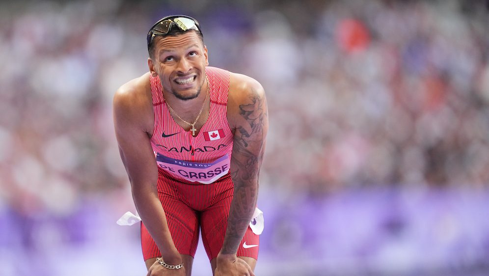 Andre De Grasse réagit les mains sur les genoux.