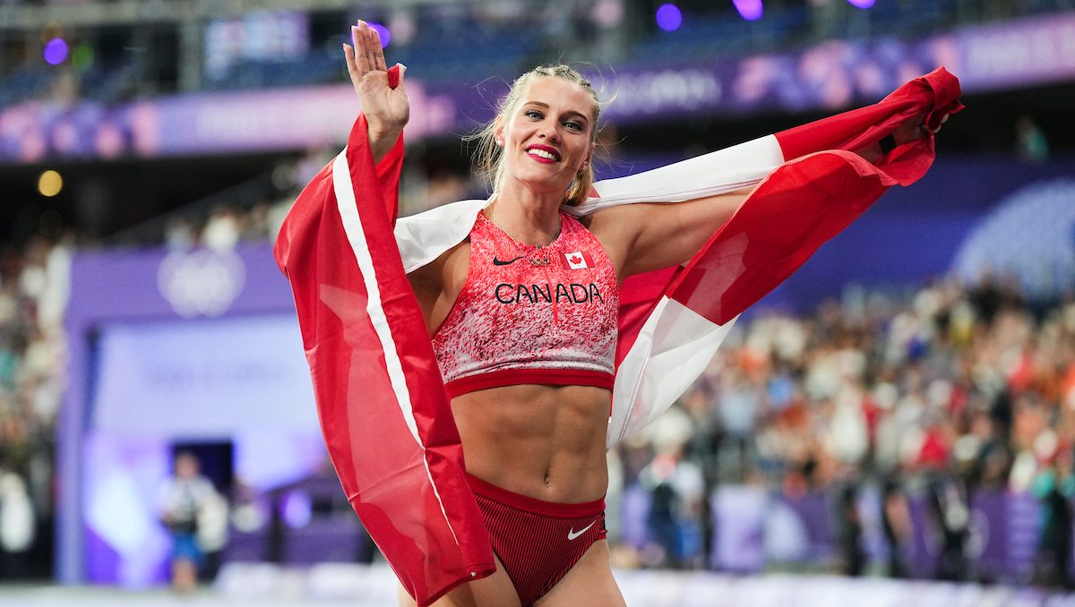 Alysha Newman avec le drapeau canadien sur les épaules. 