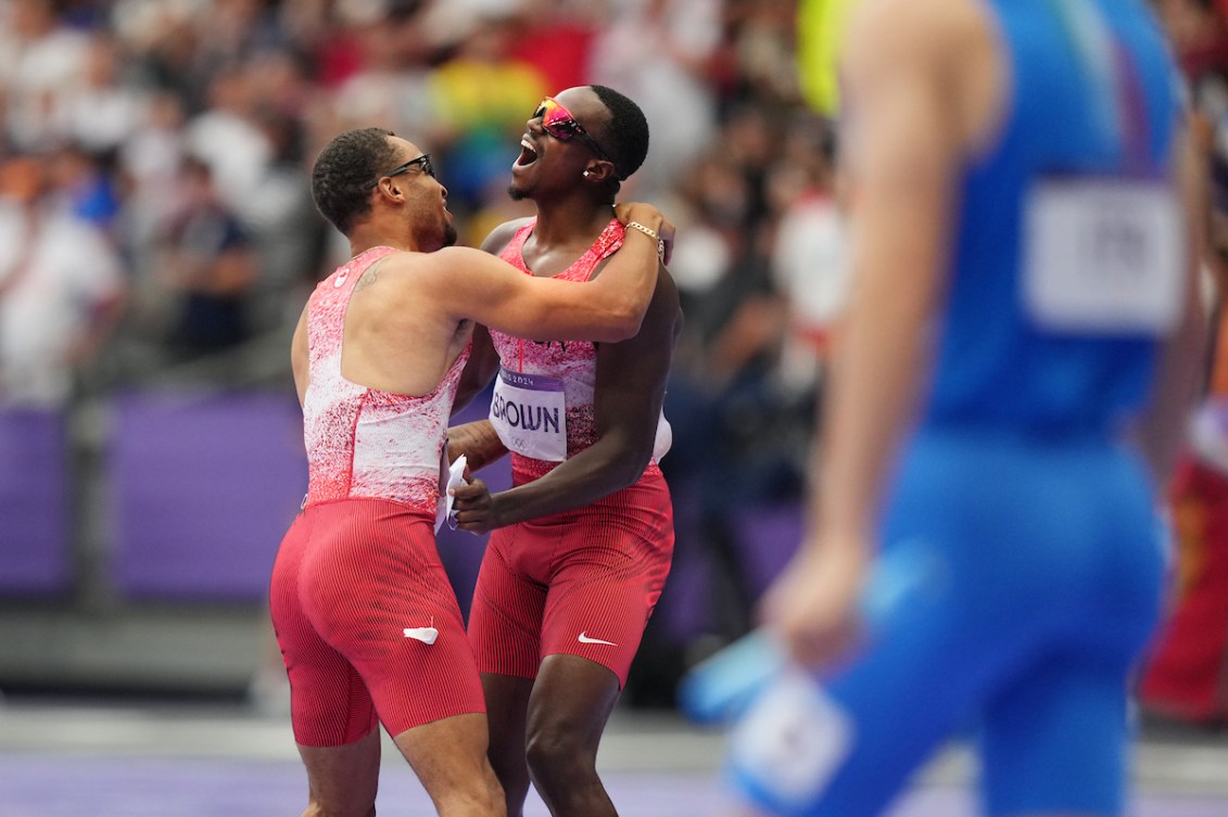 Andre De Grasse (à gauche) et Aaron Brown se serrent dans leurs bras.