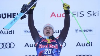 James Crawford, les bras dans les airs avec ses skis, célèbre sa victoire.