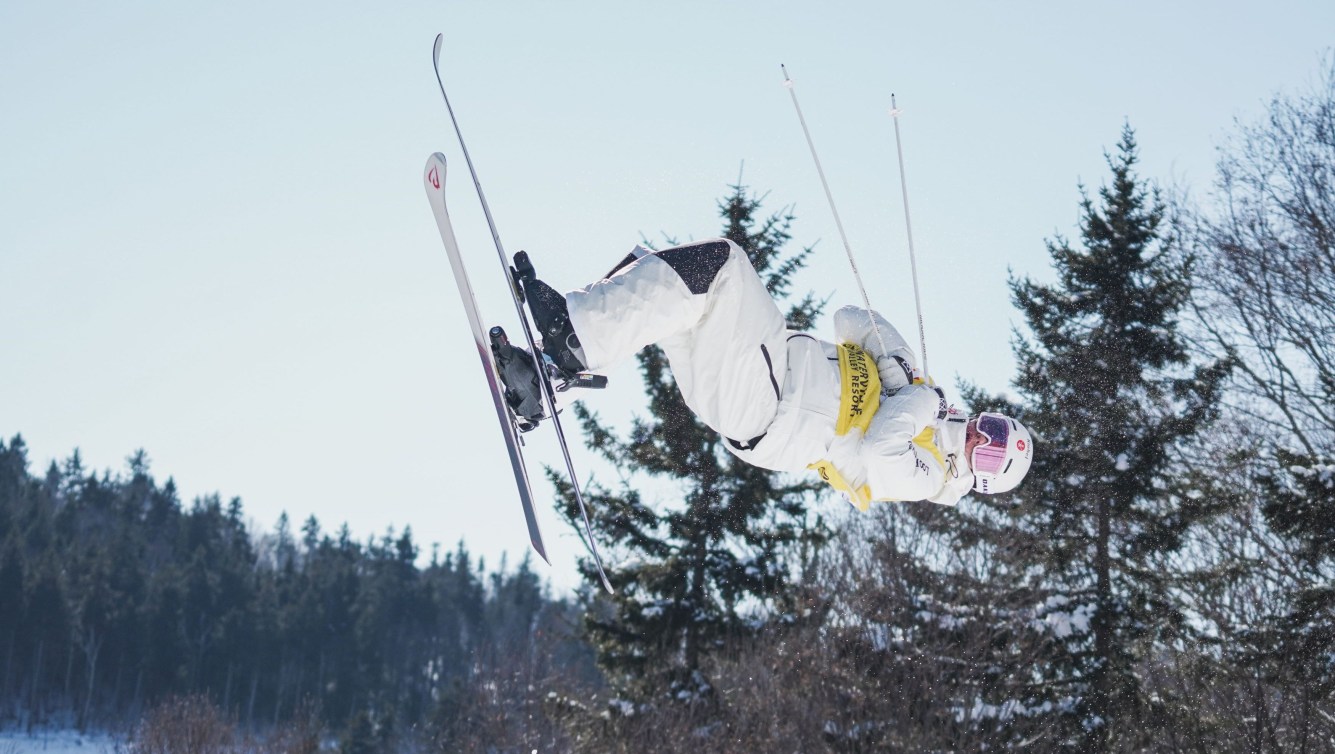 Mikaël Kingsbury dans les airs en train d'effectuer un saut.
