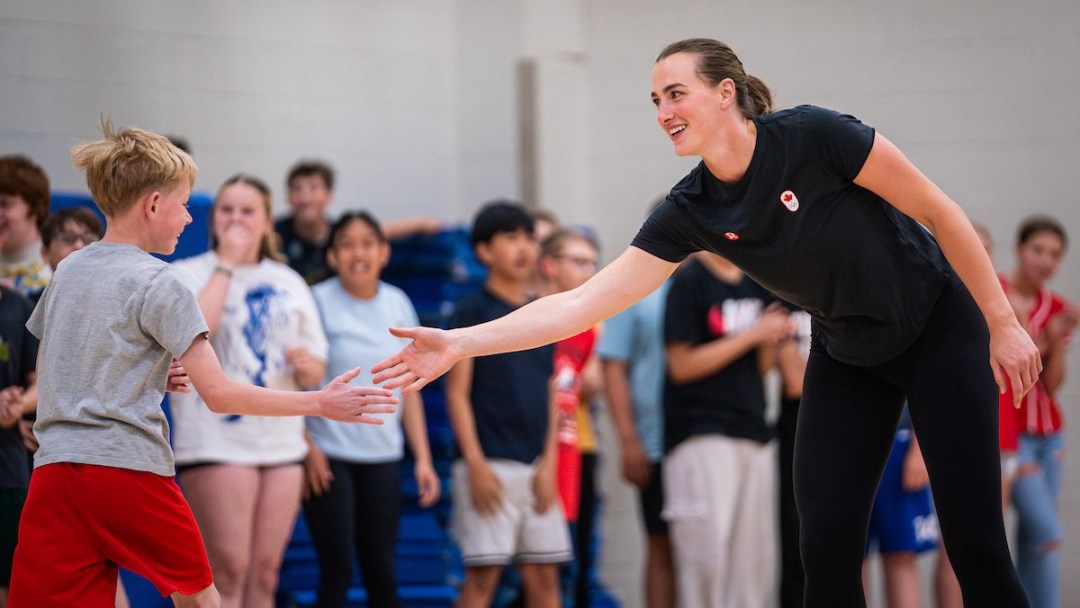 Paige Crozon high fives a student