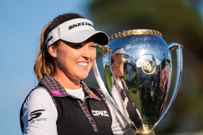 Brooke Henderson sourit en tenant un grand trophée en argent.