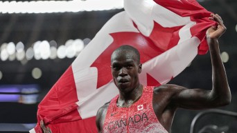 Marco Arop holds a Canadian flag behind his back