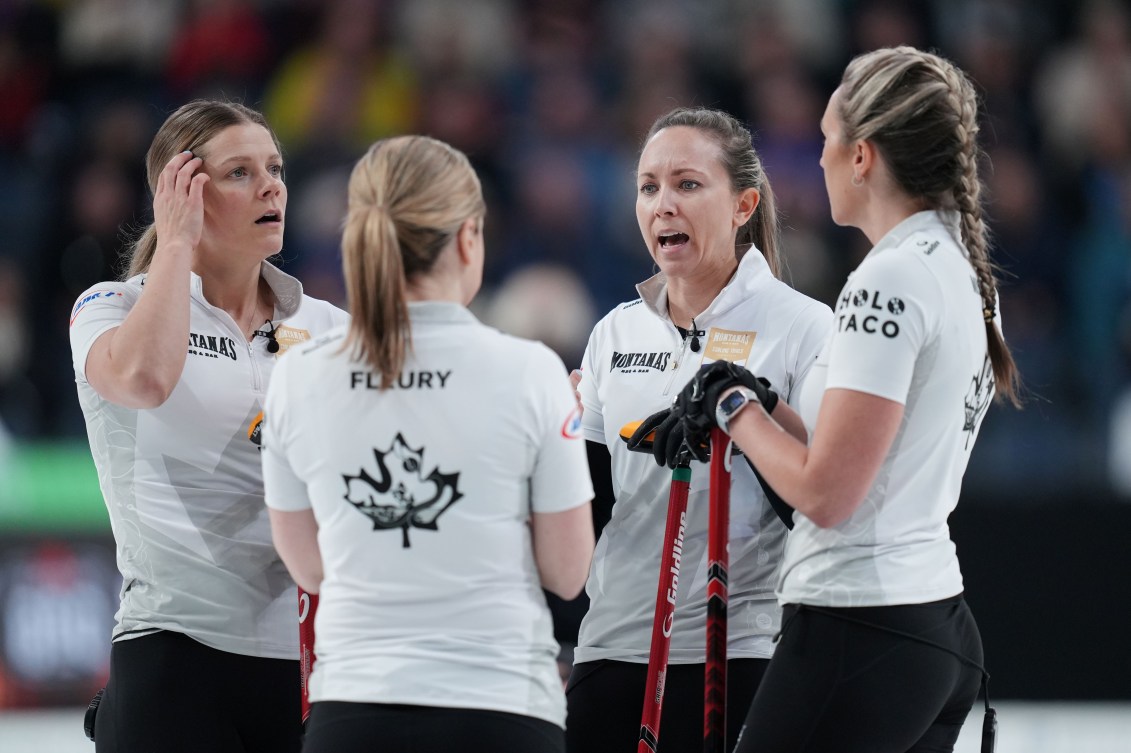 Quatre joueuses de curling en chemises blanches discutent