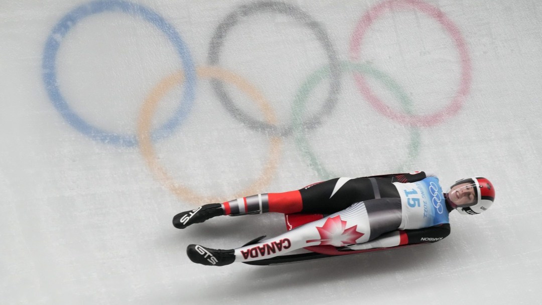 Trinity Ellis glisse devant les anneaux olympiques sur la piste de luge.