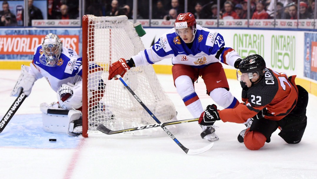 Anthony Cirelli fait une passe en étant sur les genoux.