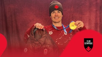 Mikael Kingsbury holding a Team Canada jacket and his gold medal